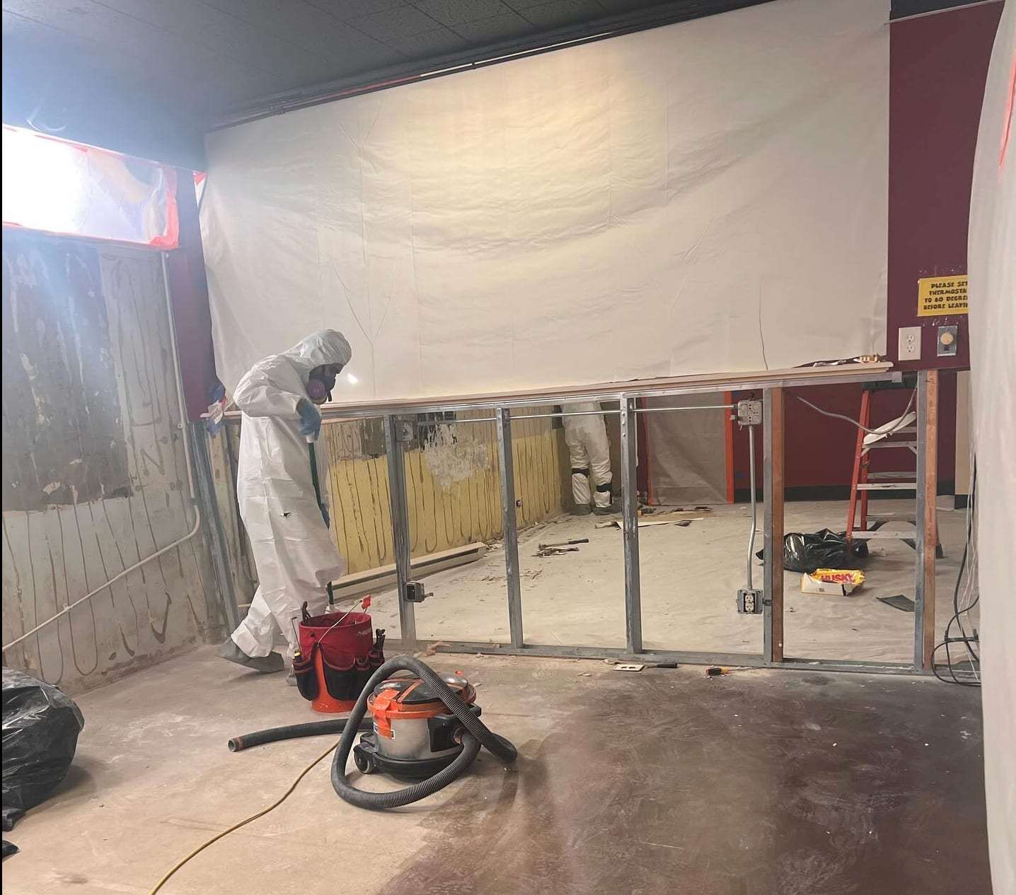 Commercial space stripped to the studs inside plastic containment